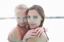 Retrato de madre e hija en piscina exterior - foto de stock