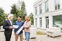 Architect discussing blueprints for building work with homeowners — Stock Photo