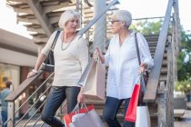 Cape Town South Africa, two elderly woman walking down the stairs with shopping bags — Stock Photo