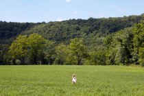 Mädchen läuft in Feld — Stockfoto