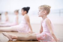 Молодые балерины, сидящие на полу в позе — стоковое фото