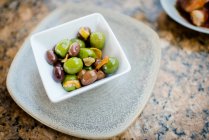 Свежие зеленые оливки в миске, вид сверху — стоковое фото