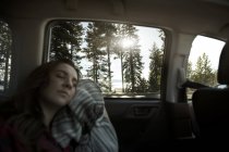 Adolescente dormir dans le siège arrière de la voiture — Photo de stock
