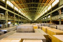 Crates in illuminated distribution warehouse, diminishing perspective — Stock Photo