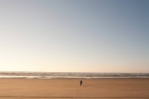 Giovane ragazzo che corre sulla spiaggia di sabbia — Foto stock