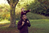 Vater trägt Kleinkind-Tochter auf Schultern — Stockfoto