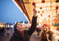 Молодая пара выбирает безделушки на рождественском фестивале в Гайд-парке, Лондон, Великобритания — стоковое фото
