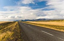 Rural road under cloudy sky — Stock Photo
