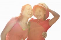 Portrait of woman embracing daughter in sunlight — Stock Photo