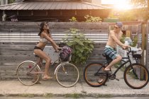Parejas jóvenes en bicicleta, Rockaway Beach, New York State, Estados Unidos - foto de stock