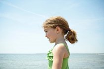 Усміхнена дівчина стоїть на пляжі — стокове фото