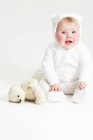 Portrait of smiling baby girl and teddy bear — Stock Photo