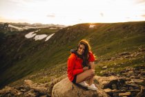 Femme assise sur un rocher et regardant une caméra, Rocky Mountain National Park, Colorado, USA — Photo de stock
