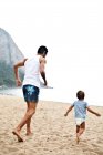 Padre e hijo jugando en la playa - foto de stock