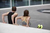 Junge Frau und Mann trainieren Liegestütze gegen die Wand — Stockfoto