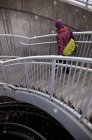 Mujer escalando escaleras en la nieve - foto de stock