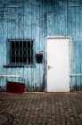 Weiße Tür auf blauem Holzgebäude — Stockfoto