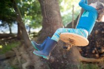 Young boy outdoors, swinging on rope swing — Stock Photo