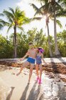 Two children fooling around on beach, wearing swimwear and snorkels — Stock Photo