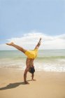 Man doing cartwheels on the beach — Stock Photo