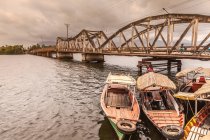 Две лодки пришвартованы на пирсе возле старого моста — стоковое фото