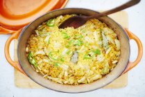 Reis in gusseiserner Schüssel mit Holzlöffel — Stockfoto