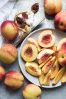 Ansicht von geschnittenen und ganzen Pfirsichen auf dem Teller — Stockfoto