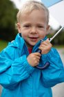 Toddler boy carrying umbrella — Stock Photo