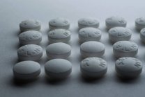 Primer plano de las pastillas de aspirina sobre fondo blanco - foto de stock