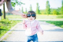 Portrait d'une petite fille portant des lunettes de soleil dans le parc — Photo de stock