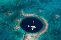 Aerial view of blue hole and helicopter — Stock Photo