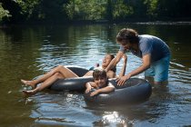 Pareja e hija divirtiéndose en el lago - foto de stock