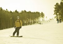 Giovane uomo snowboard giù in montagna — Foto stock
