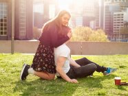 Молодая пара делает перерыв на кофе на траве, Мельбурн, Виктория, Австралия — стоковое фото