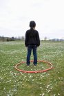 Girl standing in a hoop in a field — Stock Photo