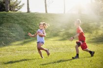 Дівчинка і хлопчик грають американський футбол — стокове фото