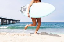 Mulher correndo com prancha de surf, Hermosa Beach, Califórnia, EUA — Fotografia de Stock