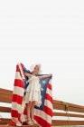 Girl holding US flag outdoors — Stock Photo