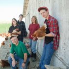 Farming family holding chickens, portrait — Stock Photo