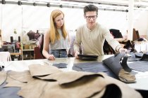 Männliche und weibliche Kollegen arbeiten in Lederjacken-Herstellern zusammen — Stockfoto