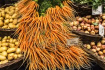 Zanahorias y patatas en cestas para la venta en el mercado - foto de stock