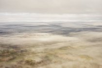 Land durch dünne Wolkenschicht gesehen — Stockfoto
