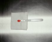 Blood covered scalpel on grey surface — Stock Photo