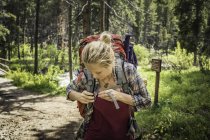 Teenager-Wandermädchen schnallt Rucksack im Wald, Red Lodge, Montana, USA — Stockfoto