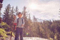 Портрет мальчика, стоящего на скале, в лесу — стоковое фото