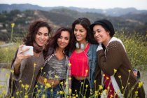 Quattro sorelle adulte in posa per selfie smartphone su strada rurale — Foto stock