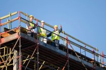 Arbeiter stehen auf Baugerüsten — Stockfoto