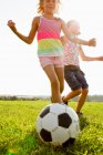 Девушки играют в футбол в поле — стоковое фото