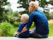 Pai e filho admirando bolhas ao ar livre — Fotografia de Stock