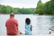Rear view of a grandfather and granddaughter fishing — Stock Photo